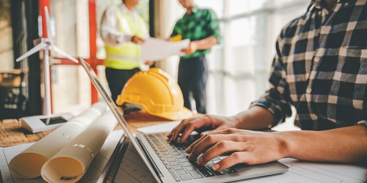 Engineers work as a team with blueprints for architectural plans. Engineer sketching construction project concept with architect equipment Architects talking at table Teamwork and construction concept contractor